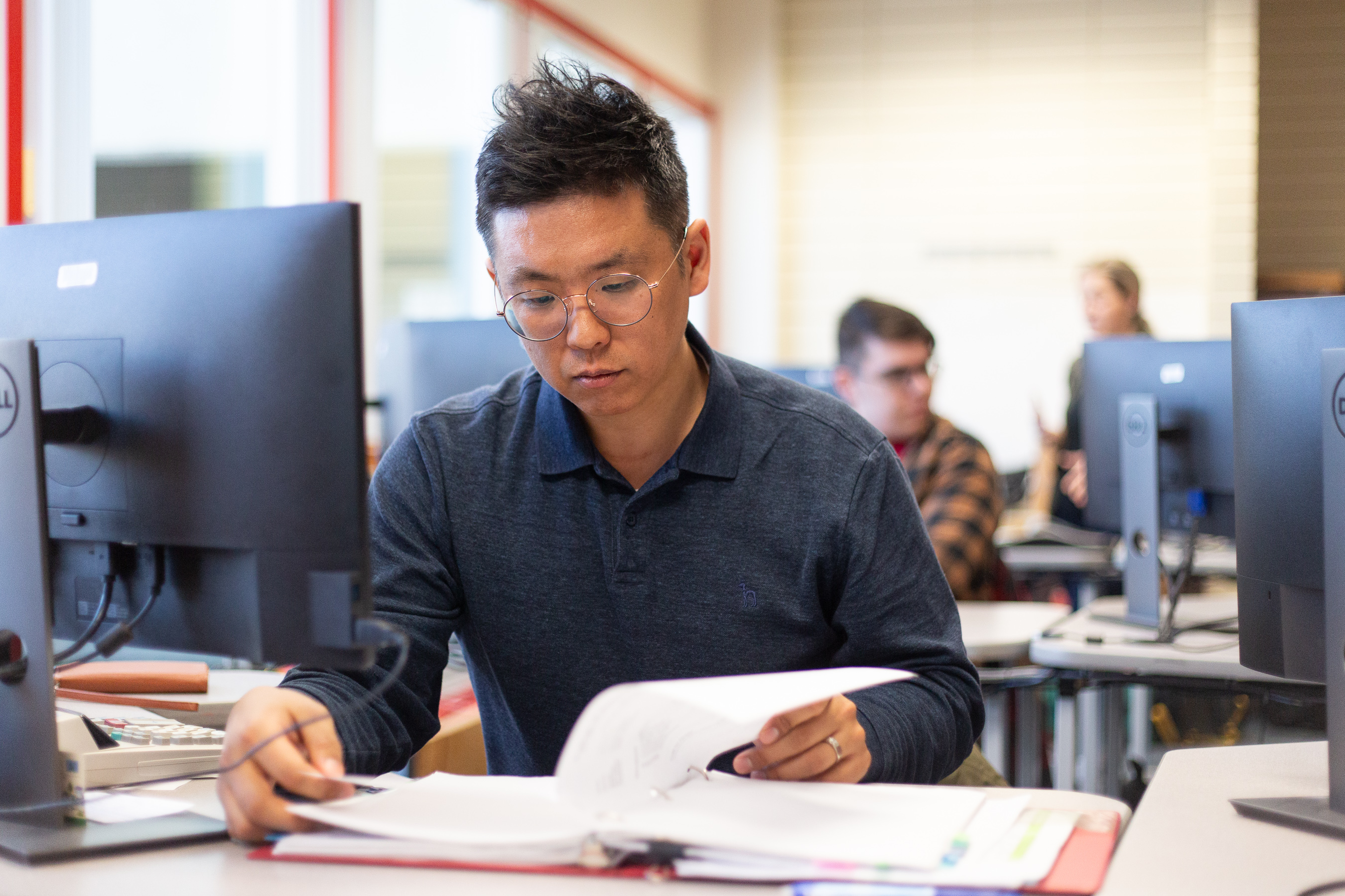 Student reading a textbook in class