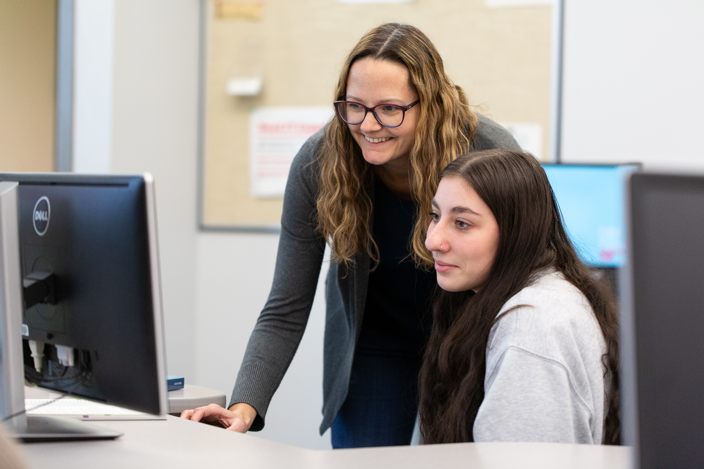 Professor helping student wit computer